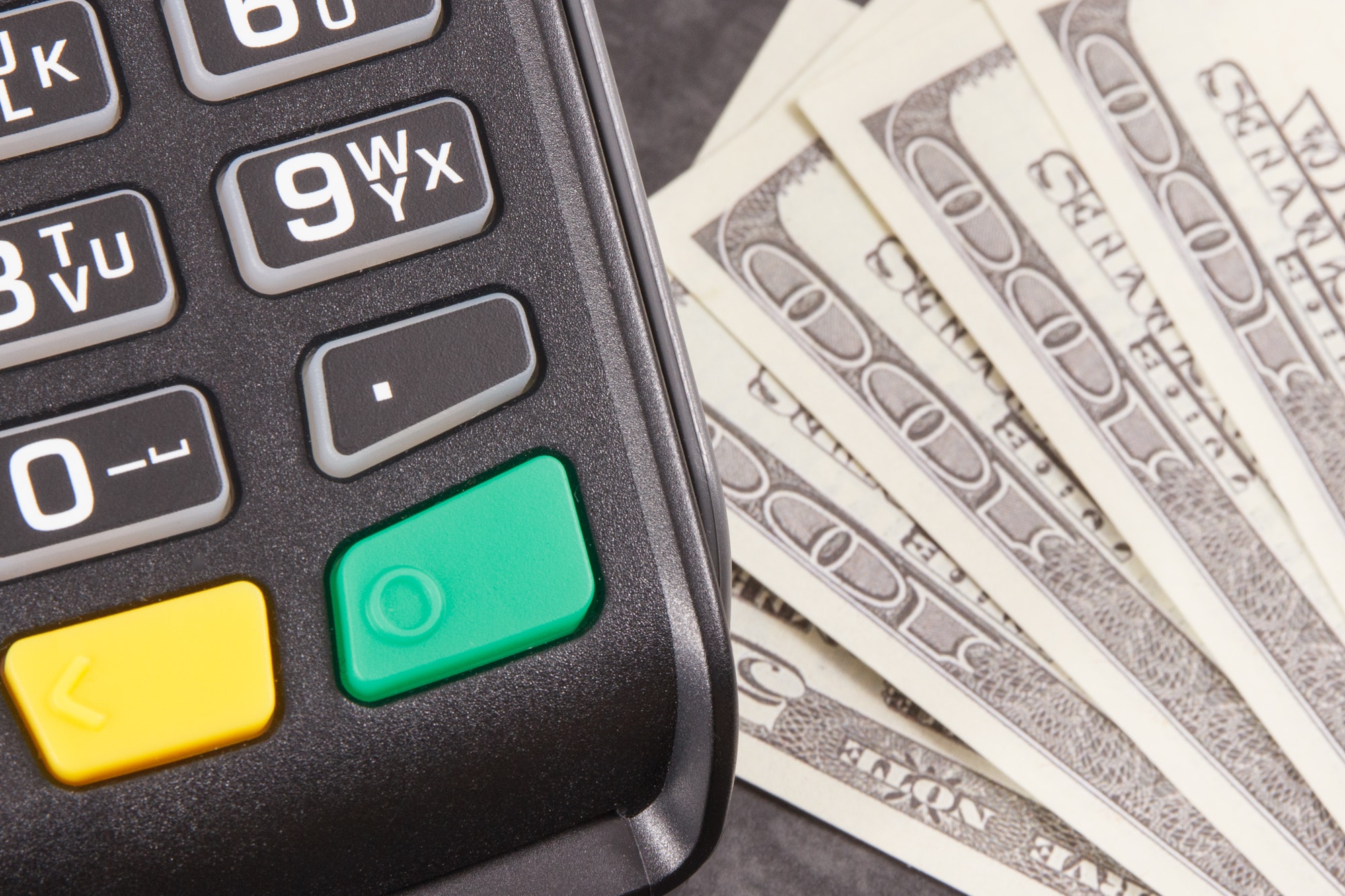 Payment terminal and curriencies dollar. Cashless or cash paying for shopping concept